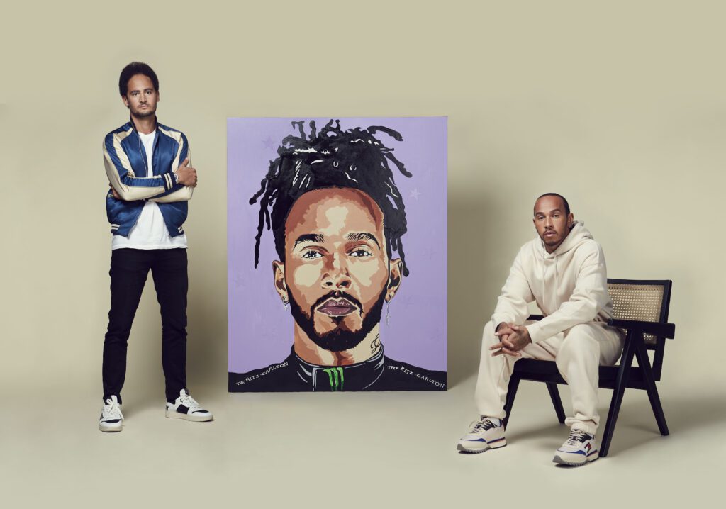 Sir Lewis Hamilton and Louis-Nicolas Darbon sat in front of one of the special edition Formula 1 posters.