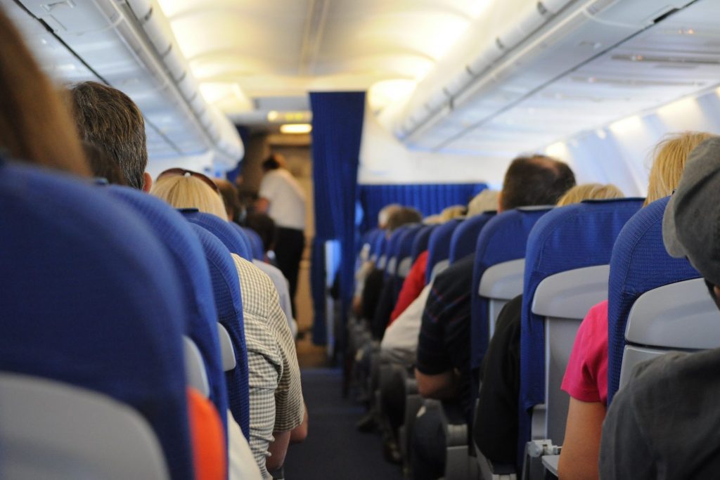 Passengers and flight attendant on an aircraft. 